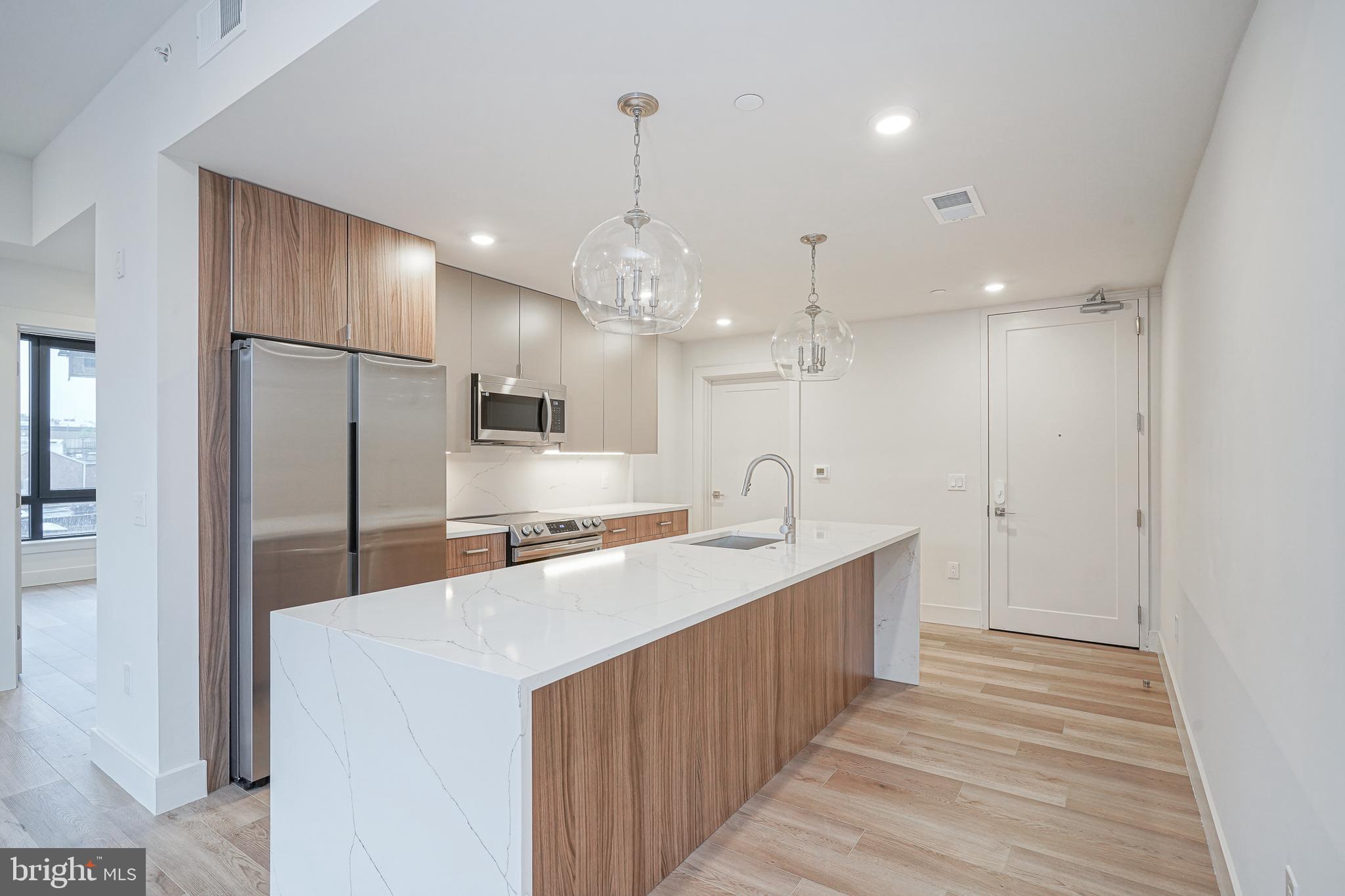 a large kitchen with kitchen island a sink stainless steel appliances and cabinets