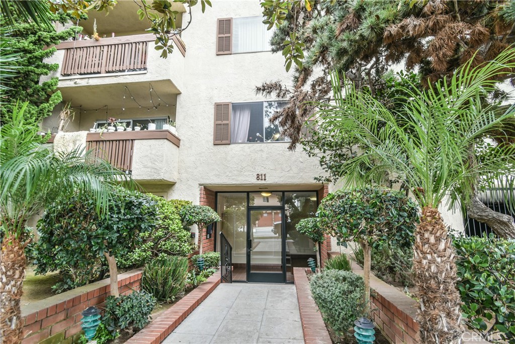 an aerial view of a house with balcony and trees all around