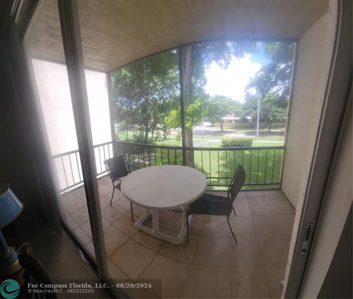 a view of a porch with furniture and a yard