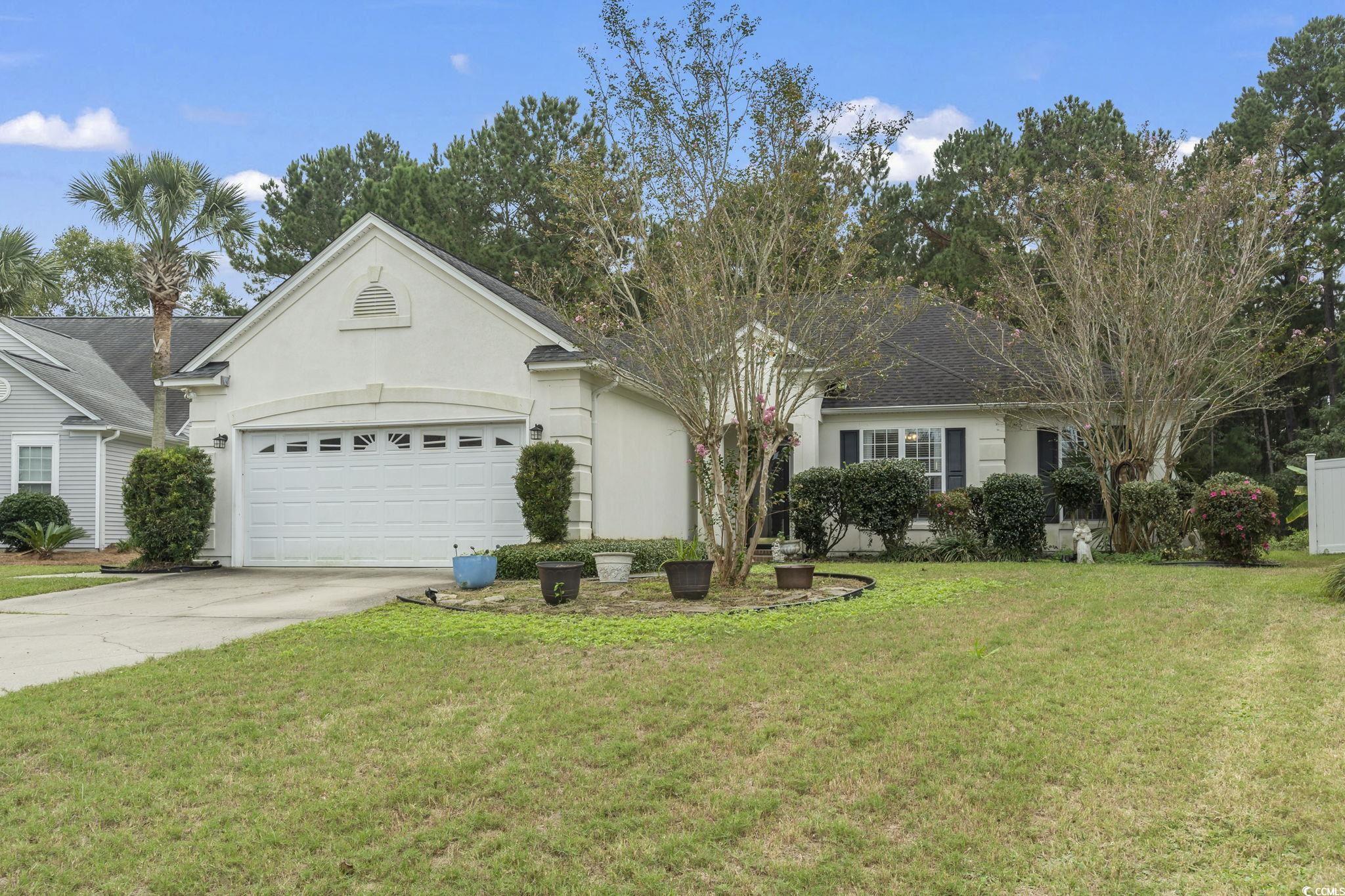 Ranch-style house with a garage and a front lawn