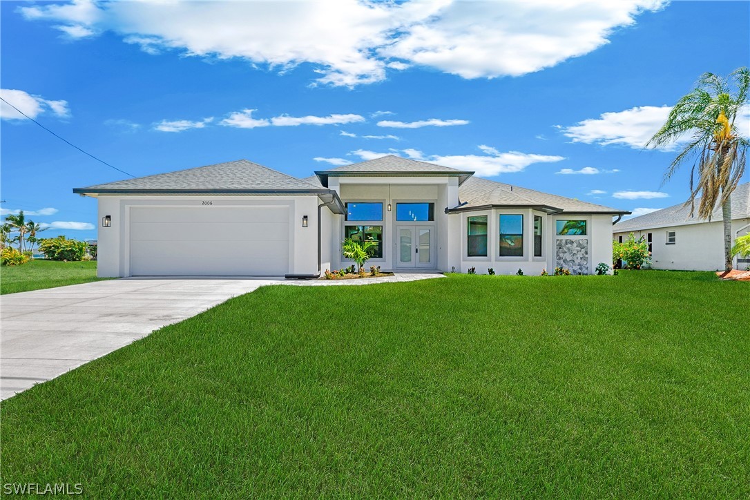 a front view of a house with a garden and yard