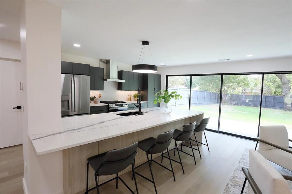 a kitchen with stainless steel appliances a table and chairs in it