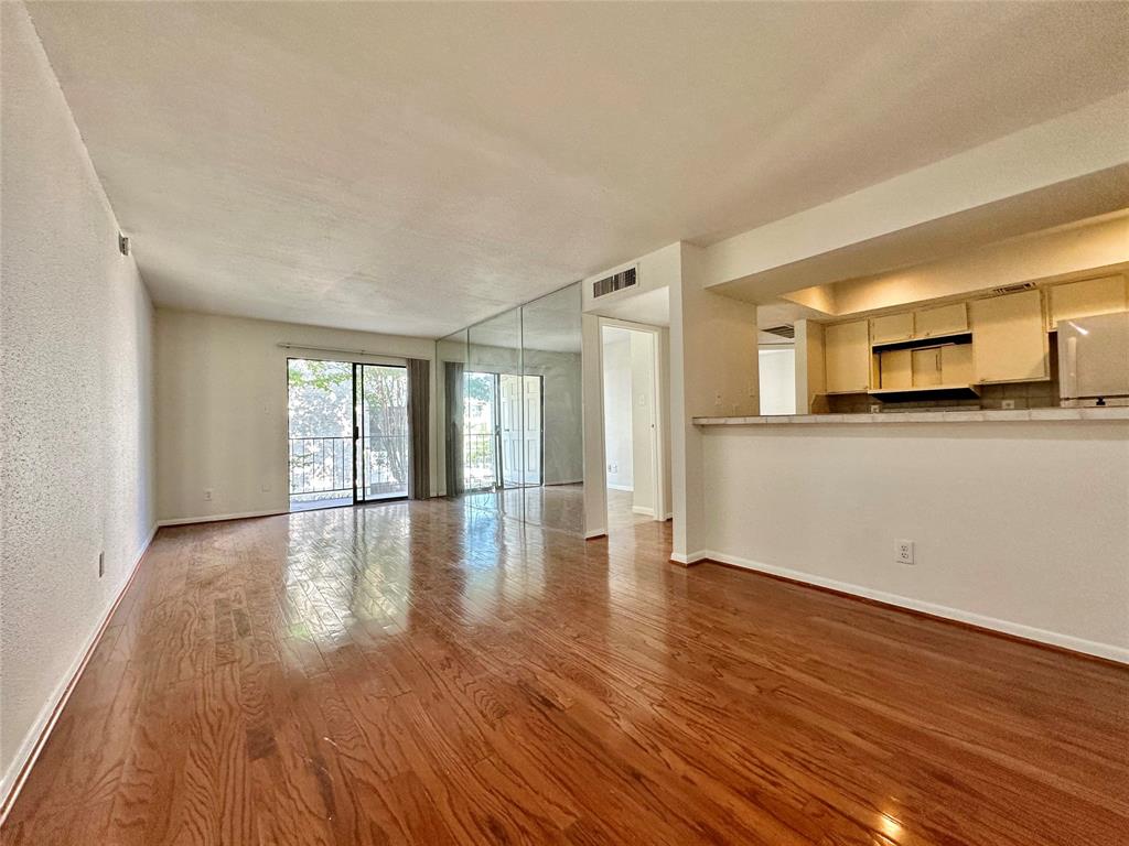 a view of a kitchen with wooden floor and a window