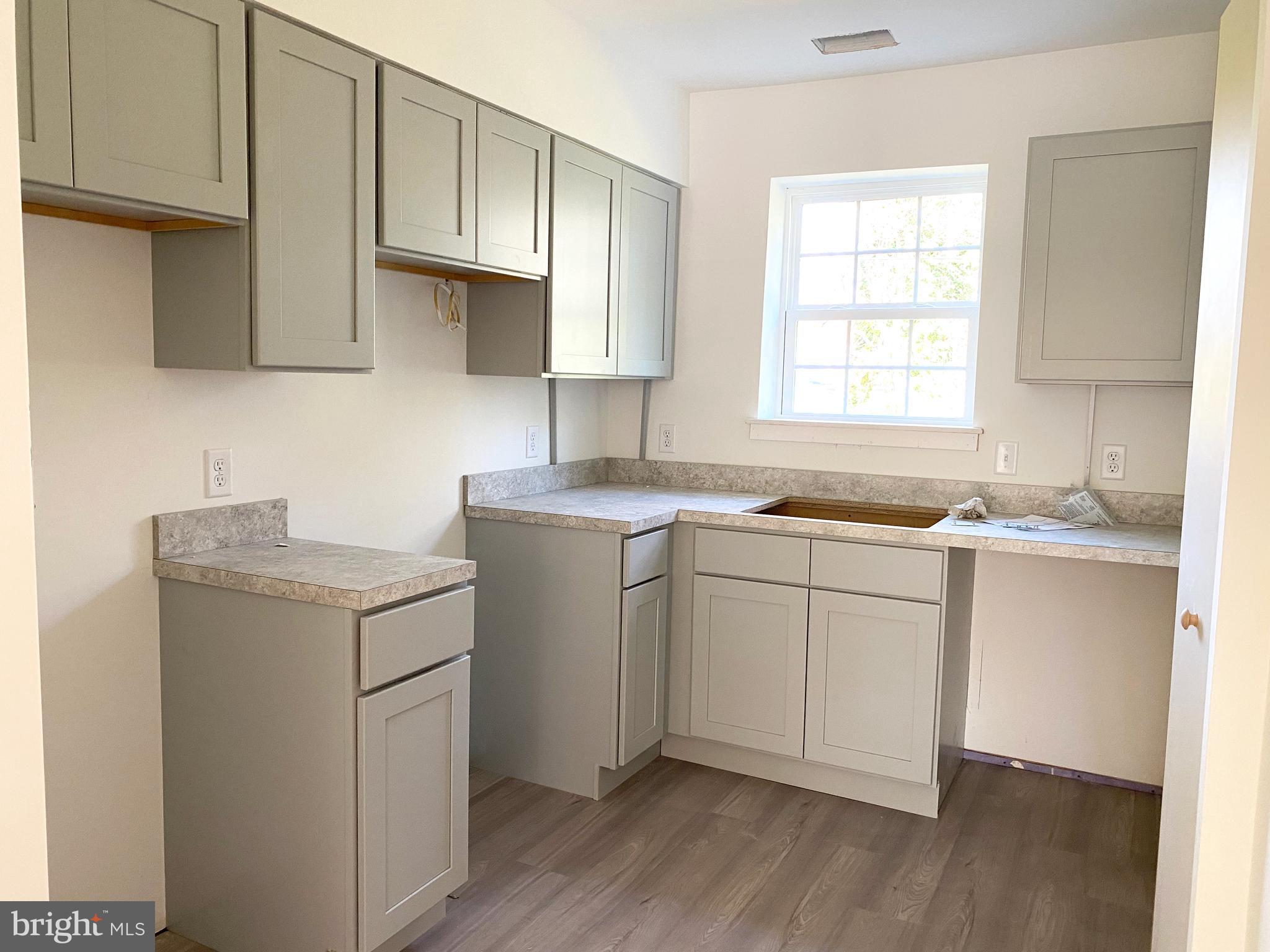 a kitchen with sink cabinets and wooden floor