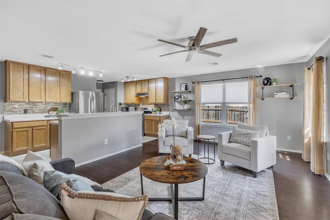 a living room with furniture and a view of kitchen