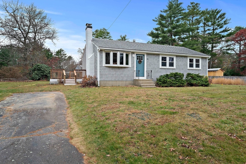 a view of a yard in front of a house with large tree