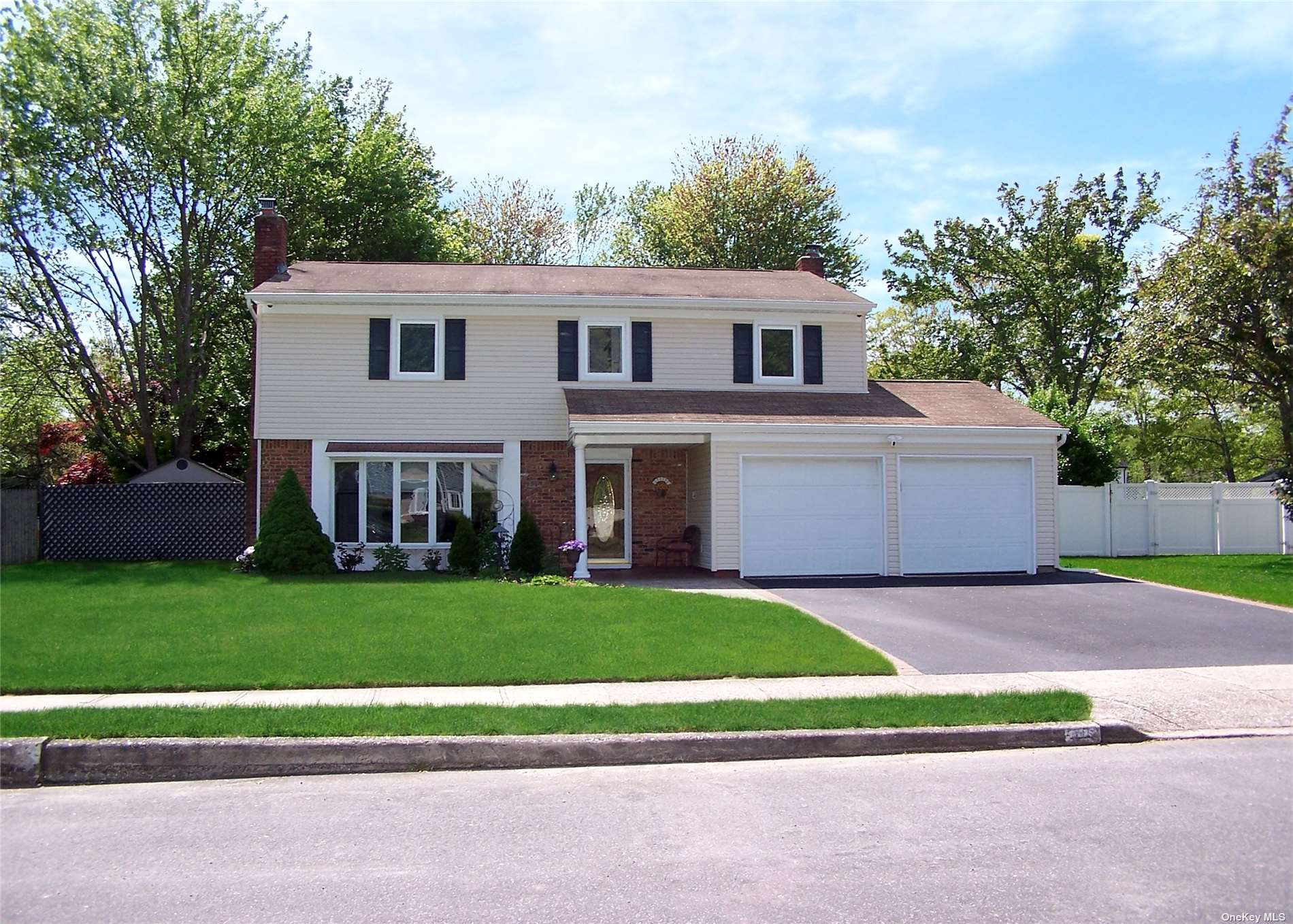 a front view of a house with a garden and yard