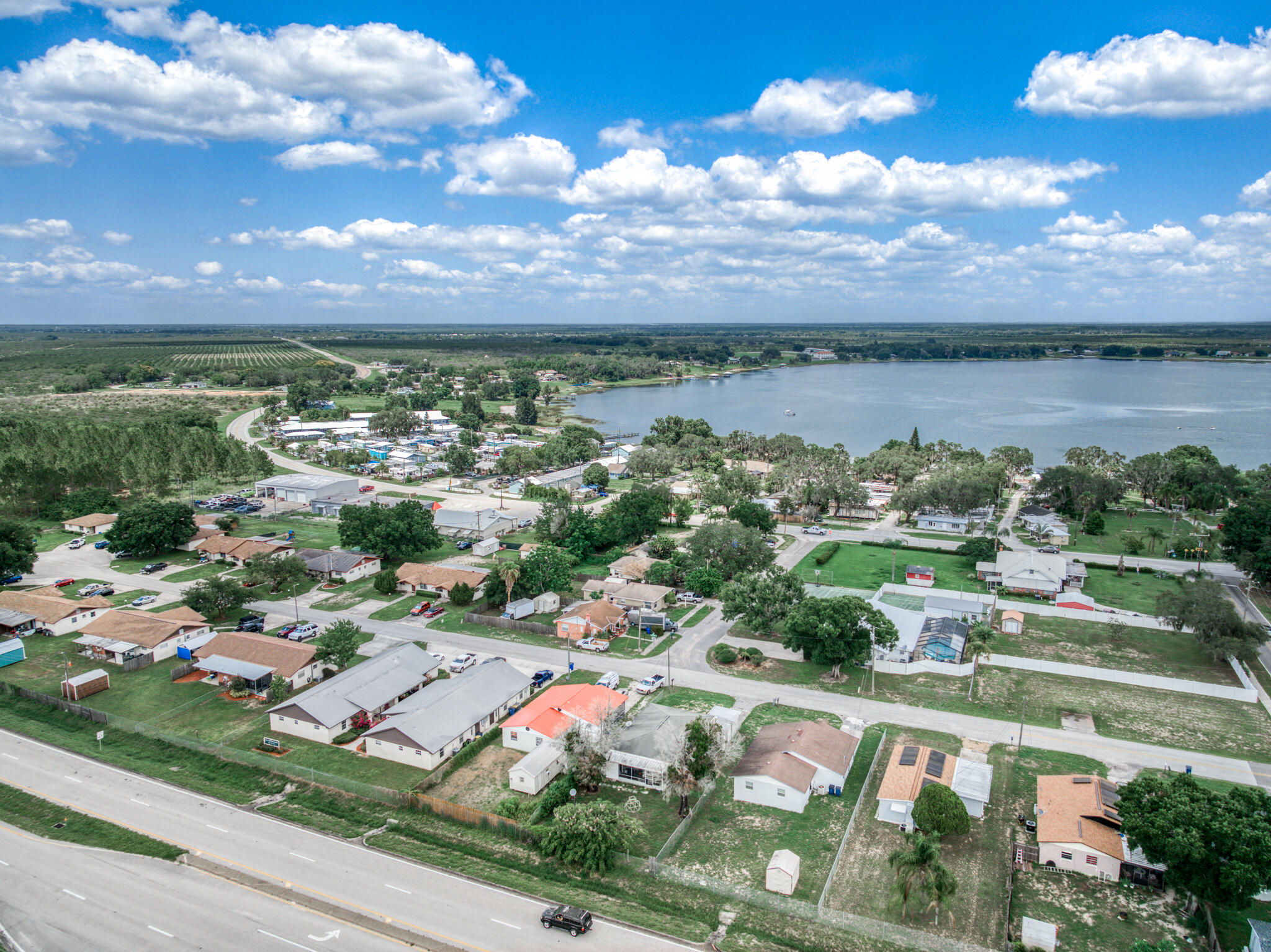 an aerial view of a city with lots of residential buildings ocean and mountain view in back