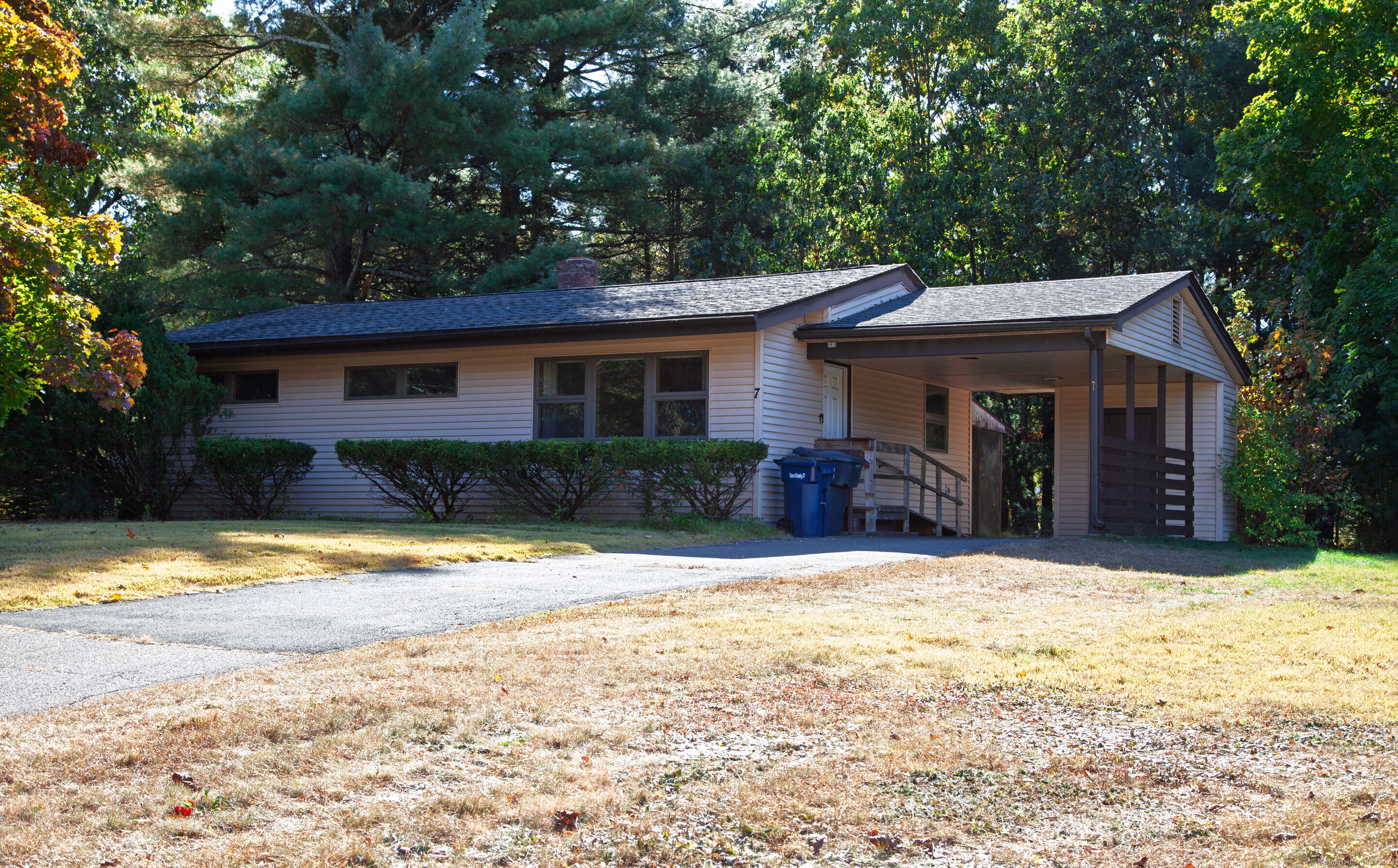 a front view of a house with a yard covered with trees