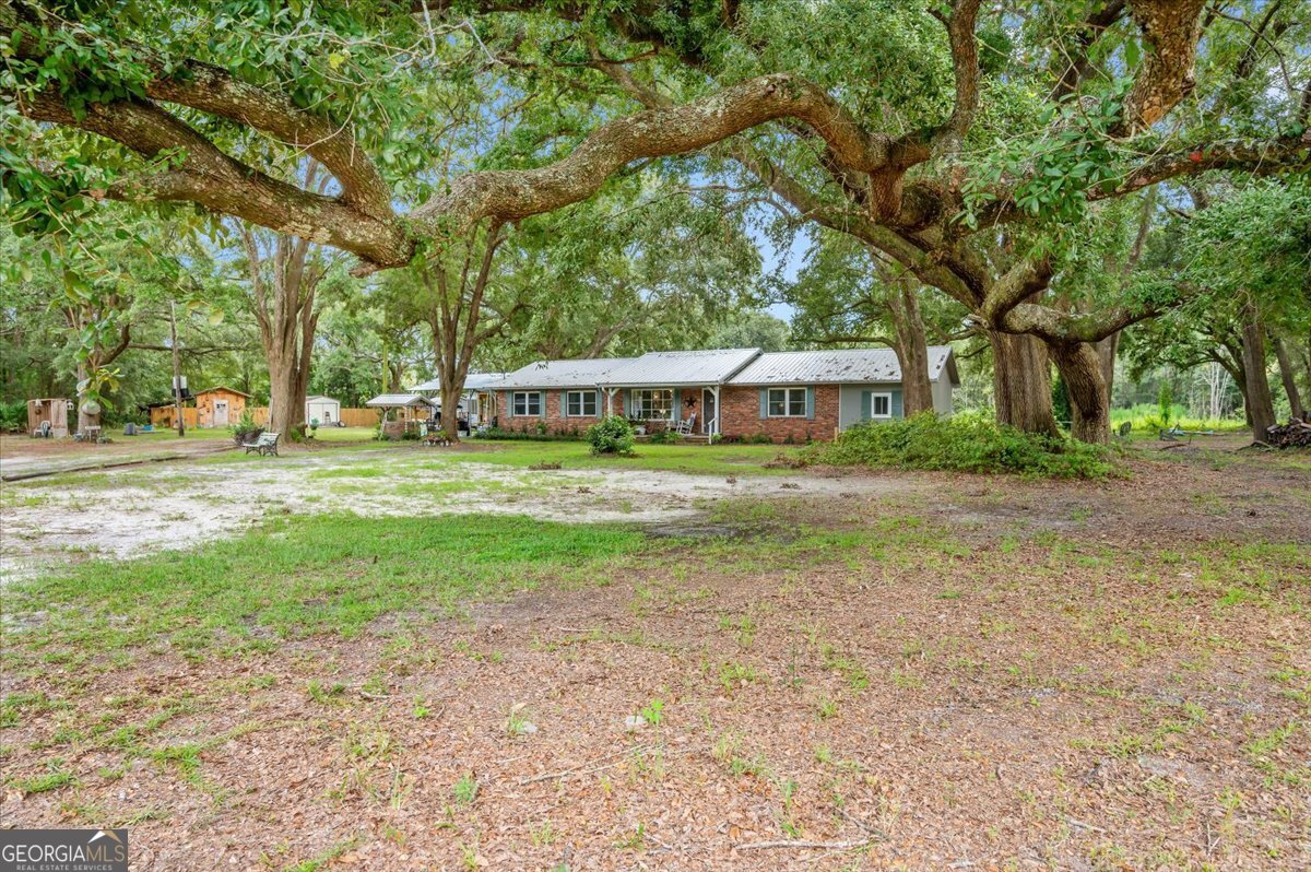 a view of a house with a yard and sitting area