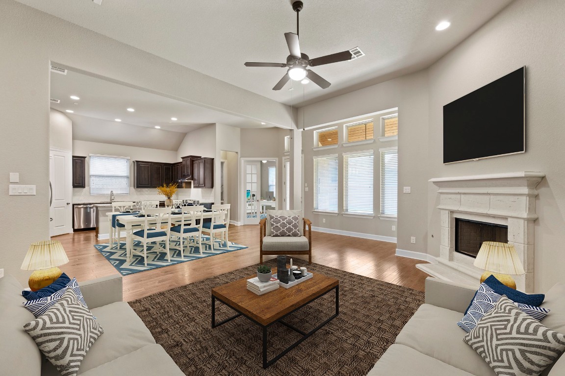 a living room with furniture a flat screen tv and a fireplace