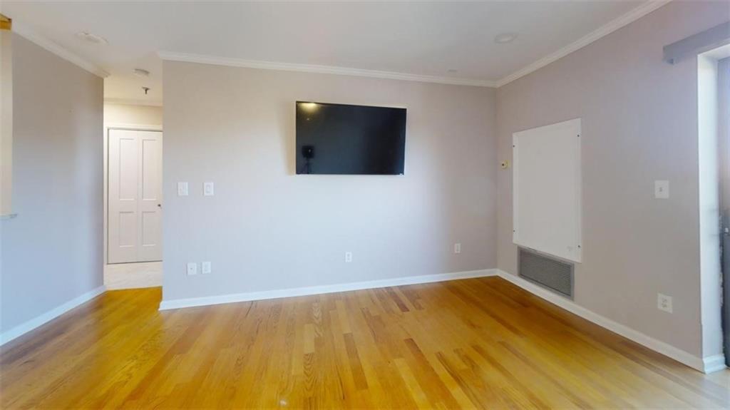 a view of a room with wooden floor and a window