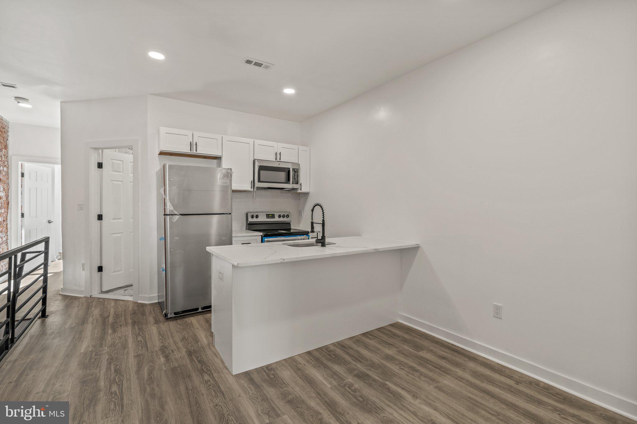 a kitchen with stainless steel appliances a refrigerator and a stove top oven