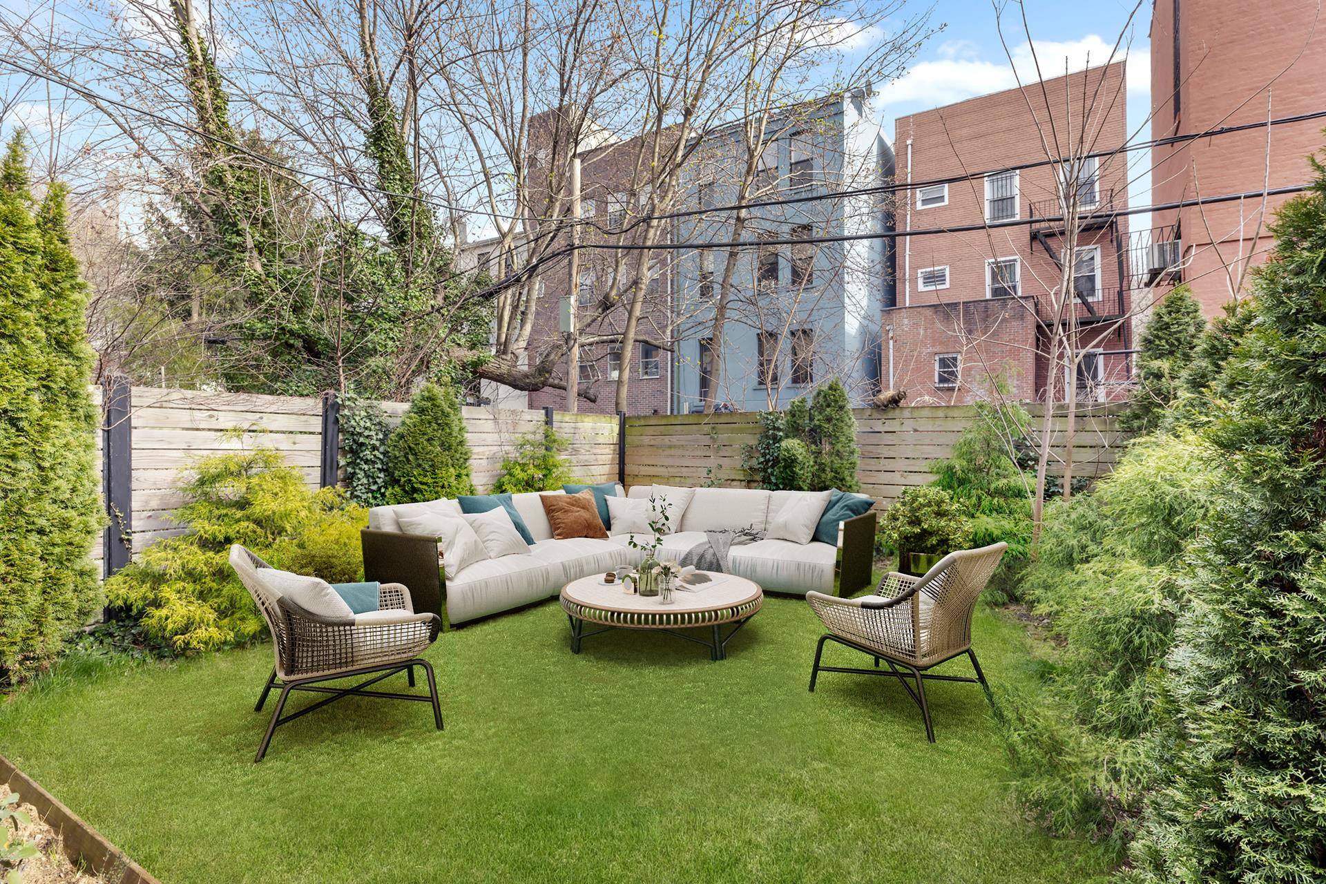 a view of a patio with couches potted plants and a large tree