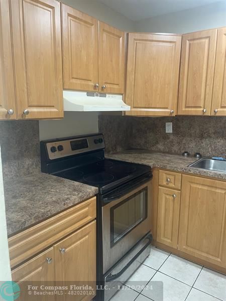 a kitchen with granite countertop white cabinets and stainless steel appliances