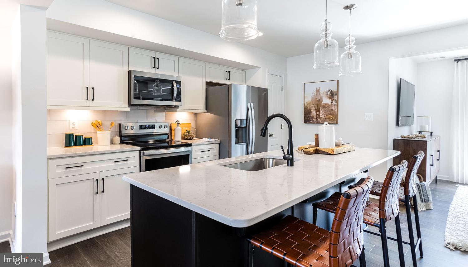 a kitchen with stainless steel appliances a table chairs microwave and cabinets