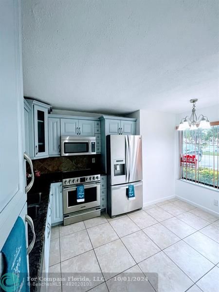 a kitchen that has a microwave a stove and a refrigerator