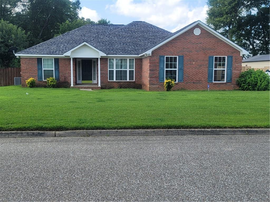 a front view of a house with a garden and trees