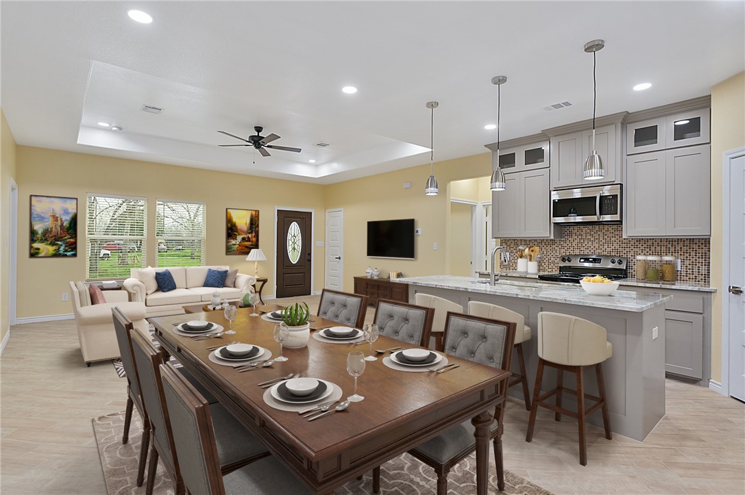 a large dining room with stainless steel appliances granite countertop a table and chairs