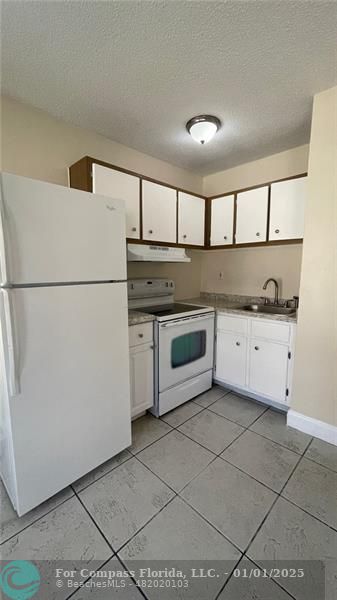 a kitchen with a stove top oven and cabinets