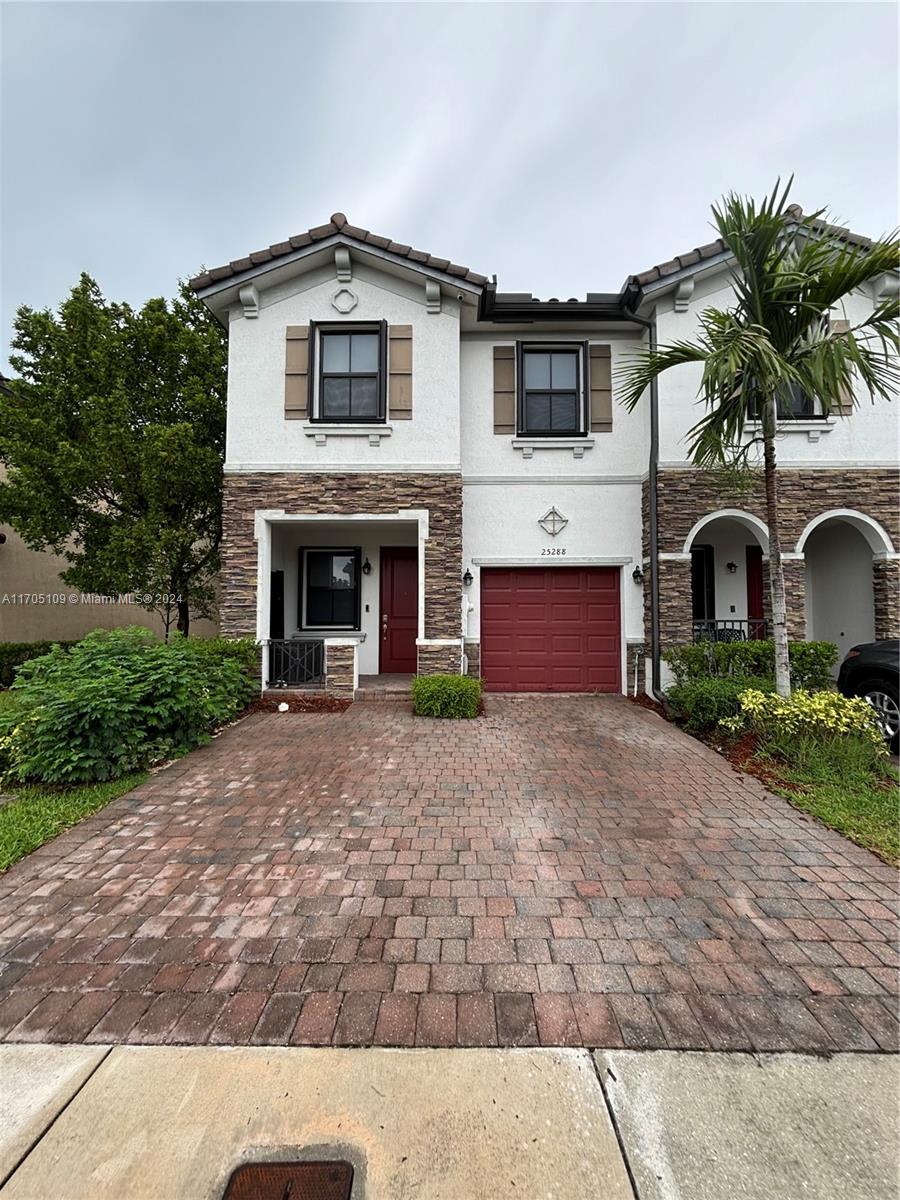 a front view of a house with yard and parking