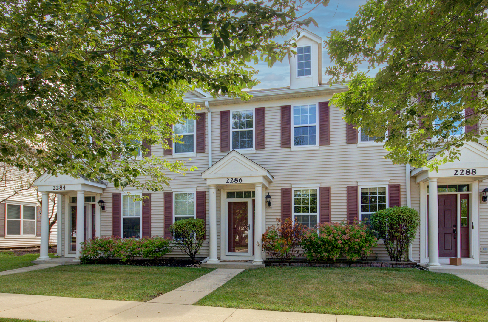 front view of a brick house with a yard