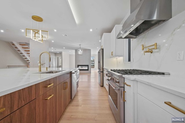 a large kitchen with stainless steel appliances granite countertop a lot of counter space and wooden floors