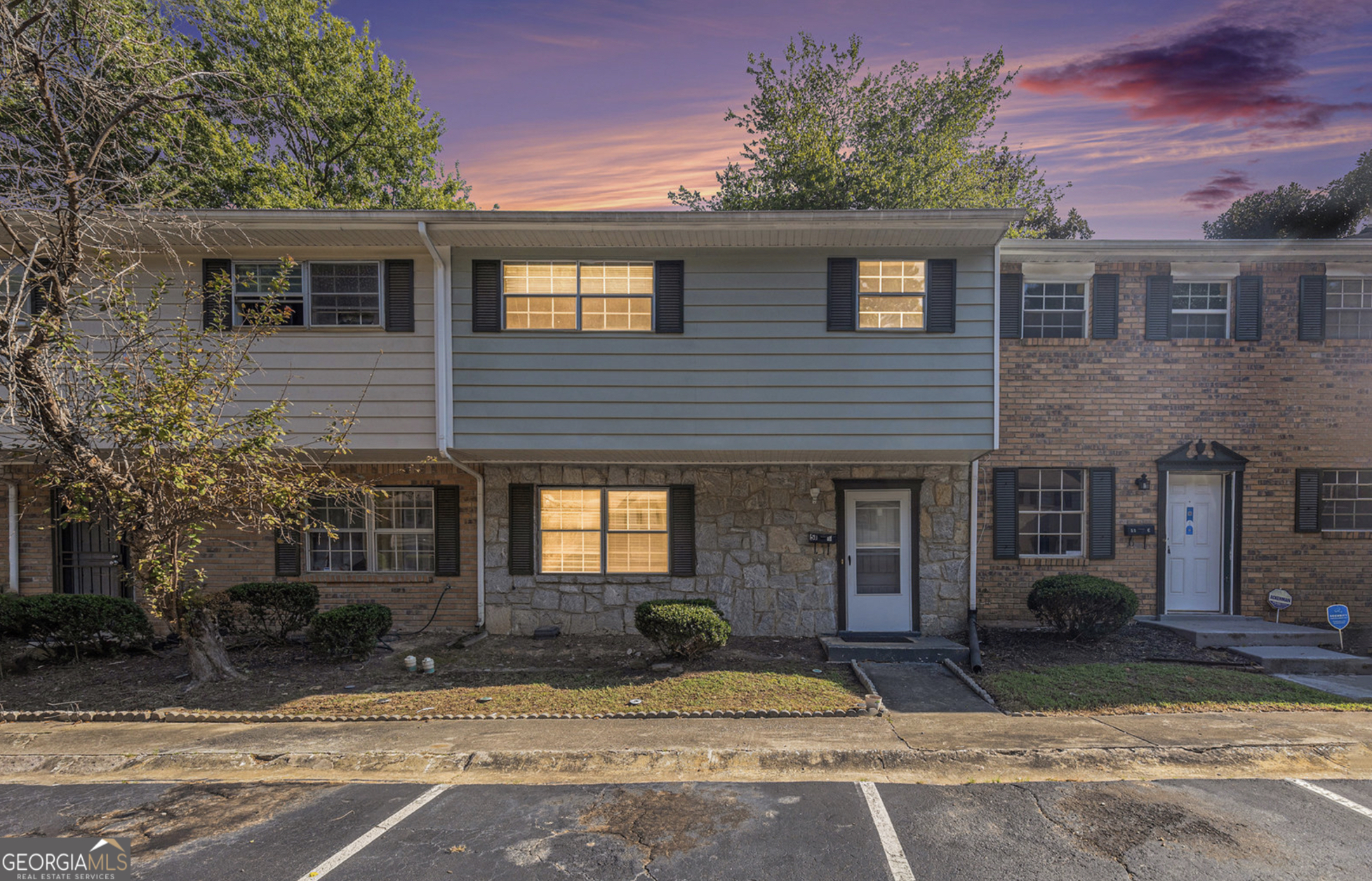 a front view of a house with yard and parking