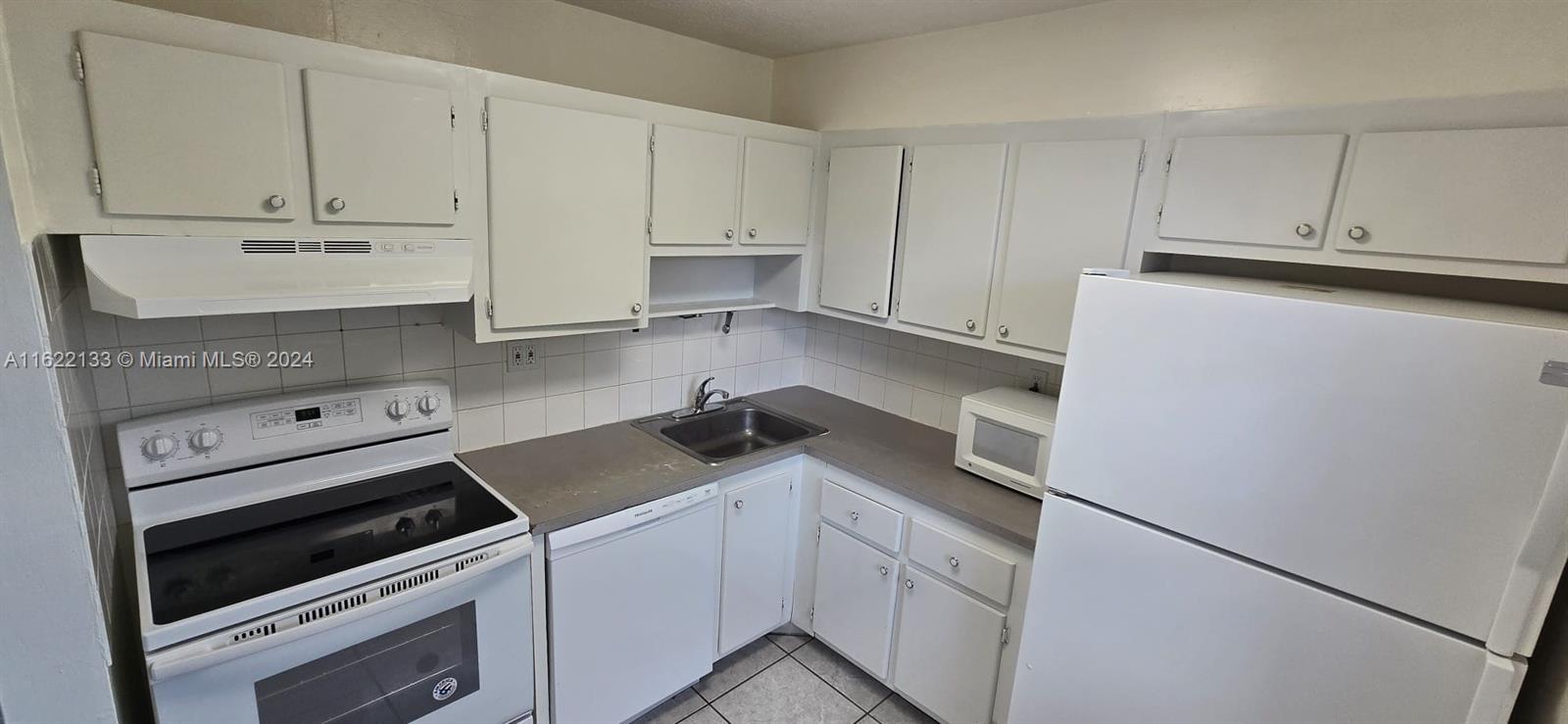 a kitchen with white cabinets and white appliances