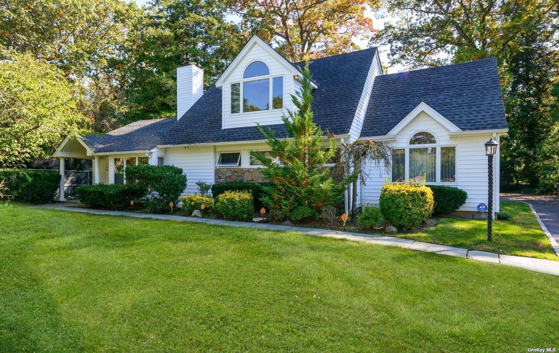 a front view of a house with a yard and green space