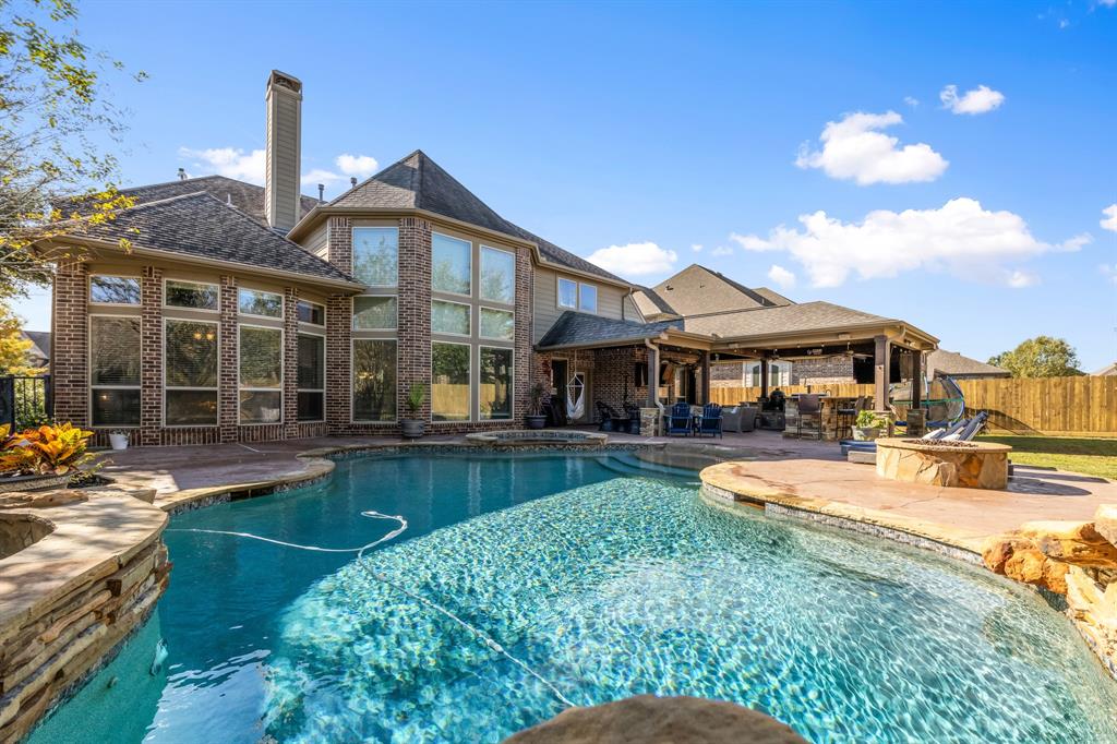 a front view of a house with swimming pool having outdoor seating