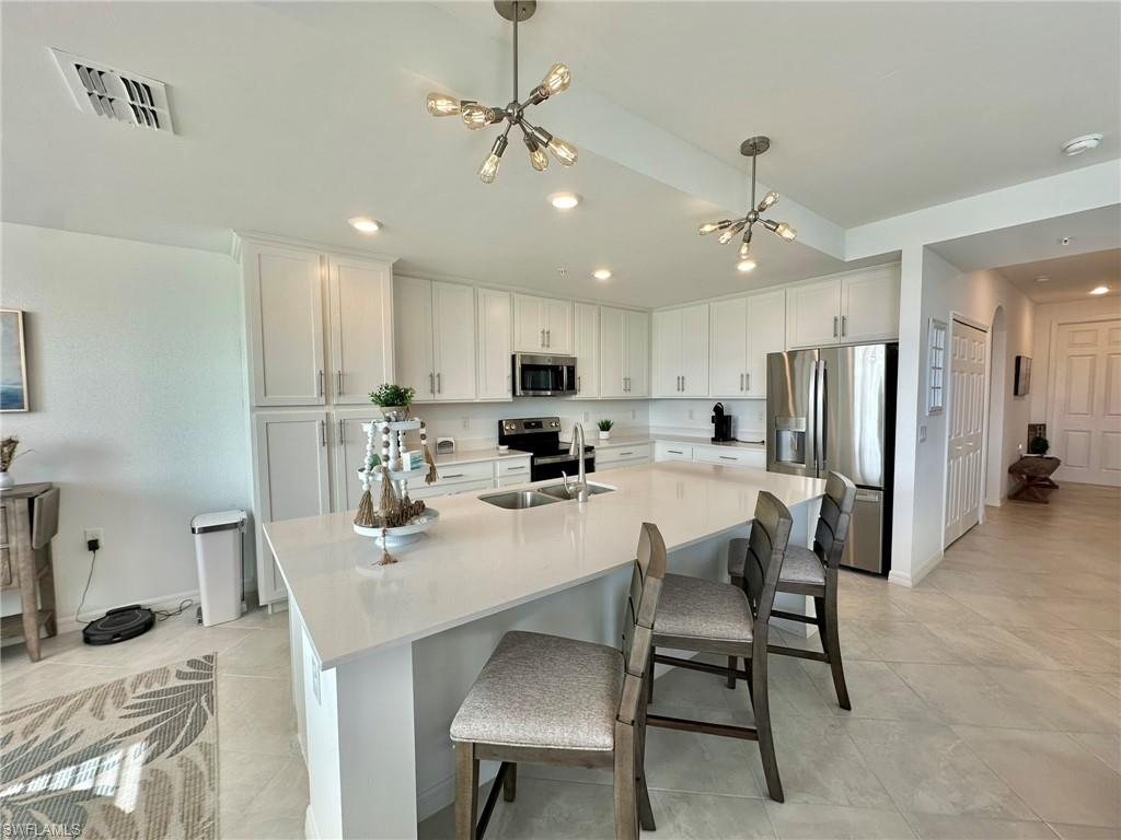 a kitchen with a dining table chairs refrigerator and microwave