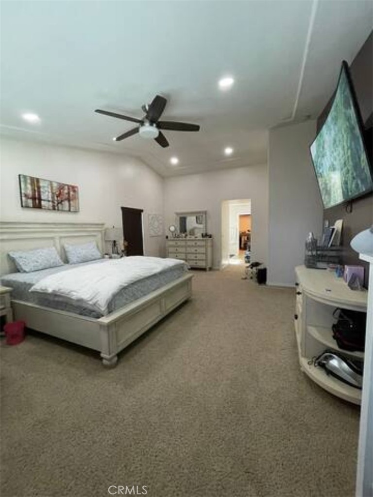 a spacious bedroom with a bed a couch and a chandelier