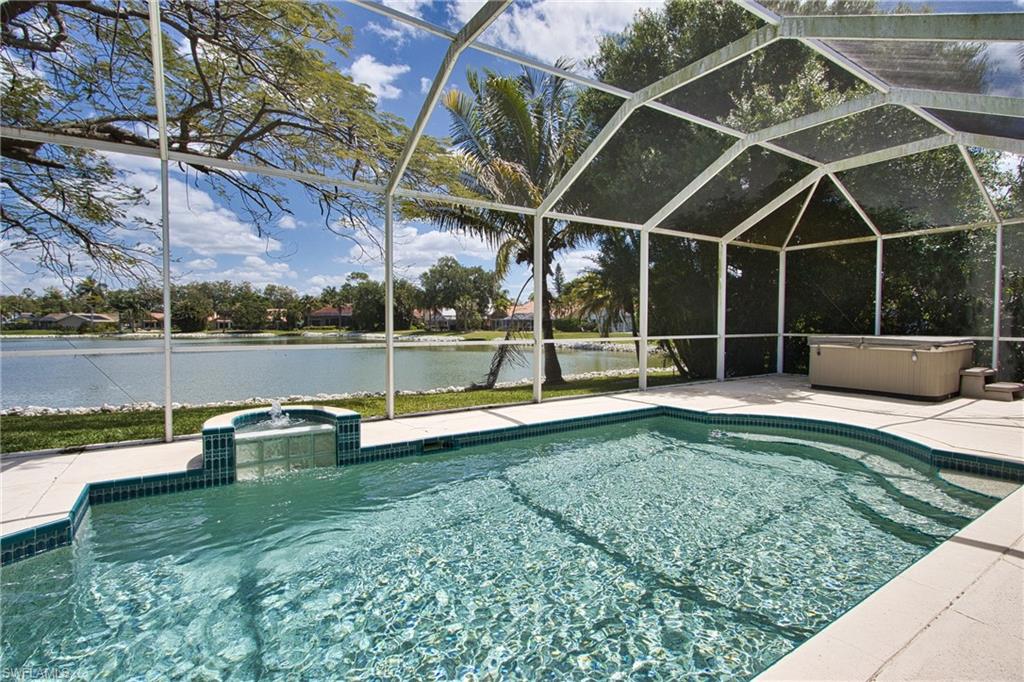 a view of a swimming pool with a bench and lawn chairs