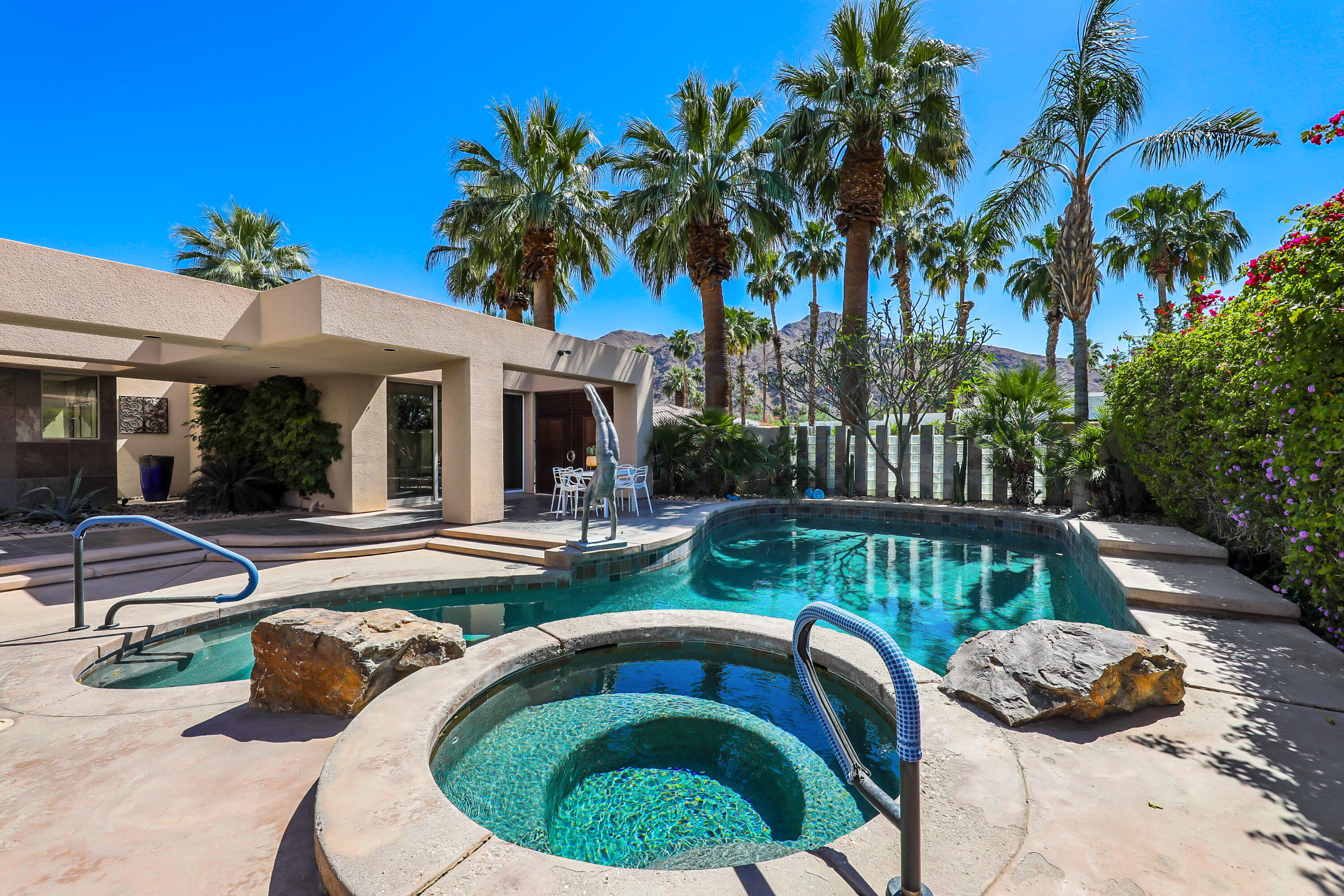 a view of a house with backyard swimming pool and sitting area