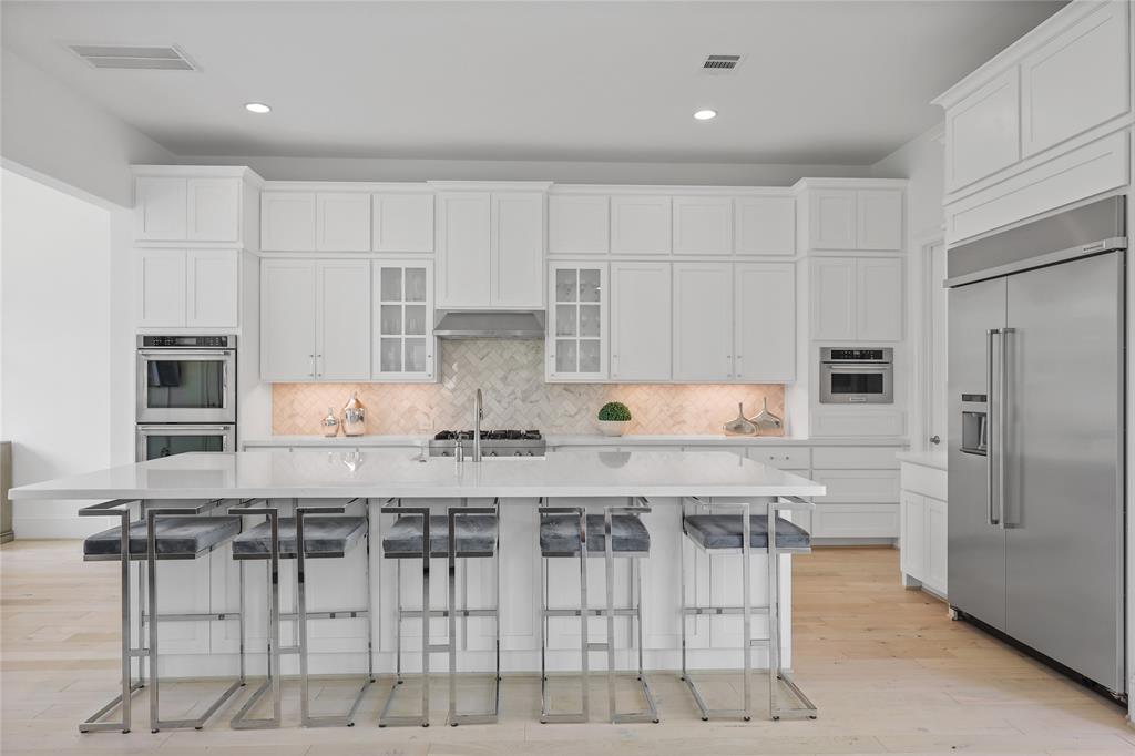 Stunning kitchen boasts expansive quarts island, commercial grade appliances and an abundance of cabinetry.