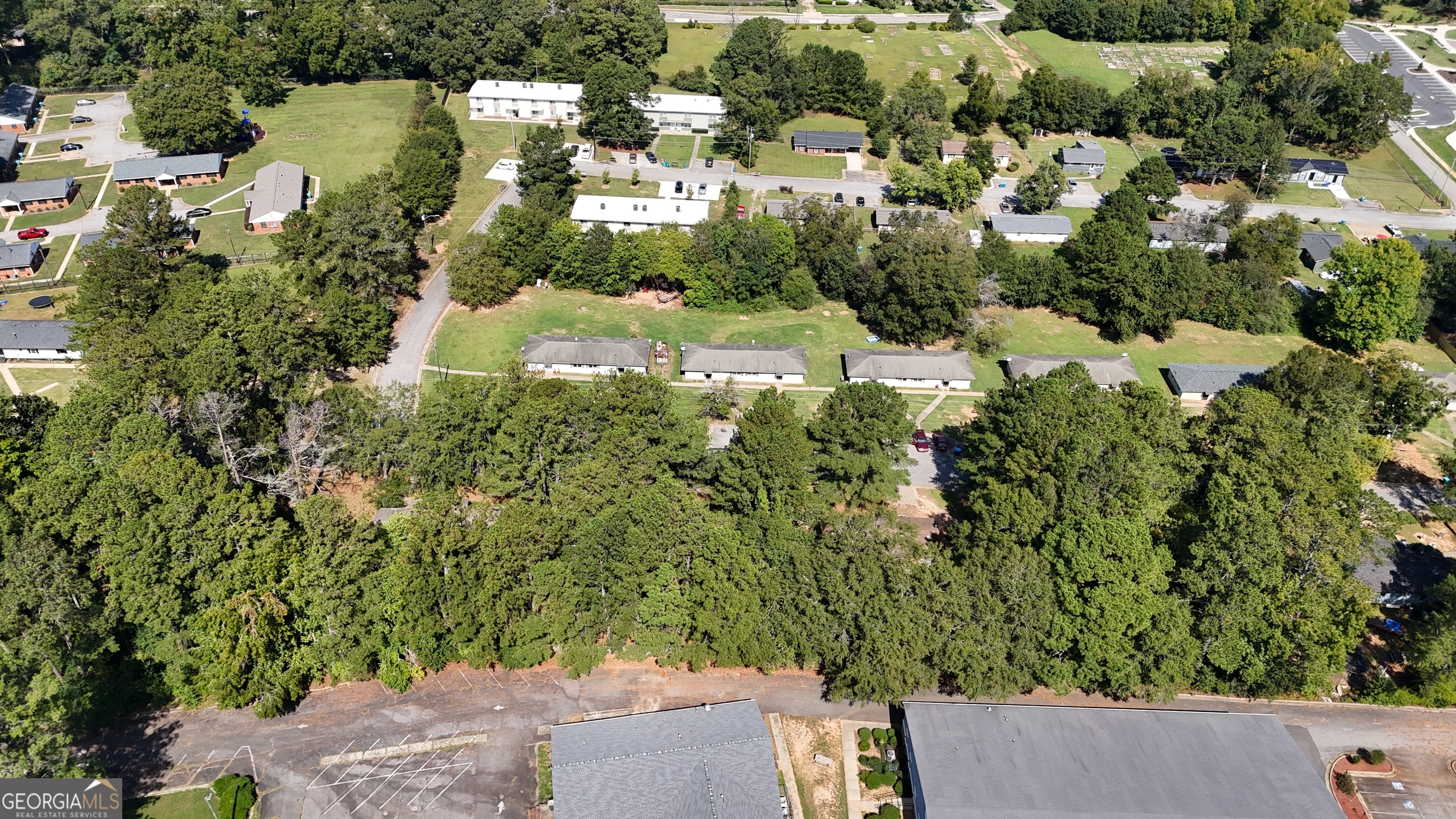 an aerial view of residential house with outdoor space and trees all around