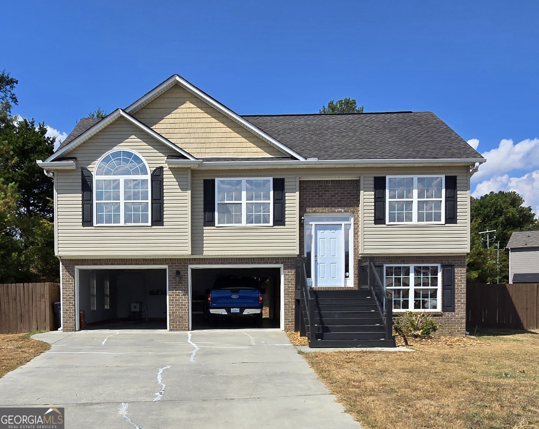 a front view of a house with yard and parking