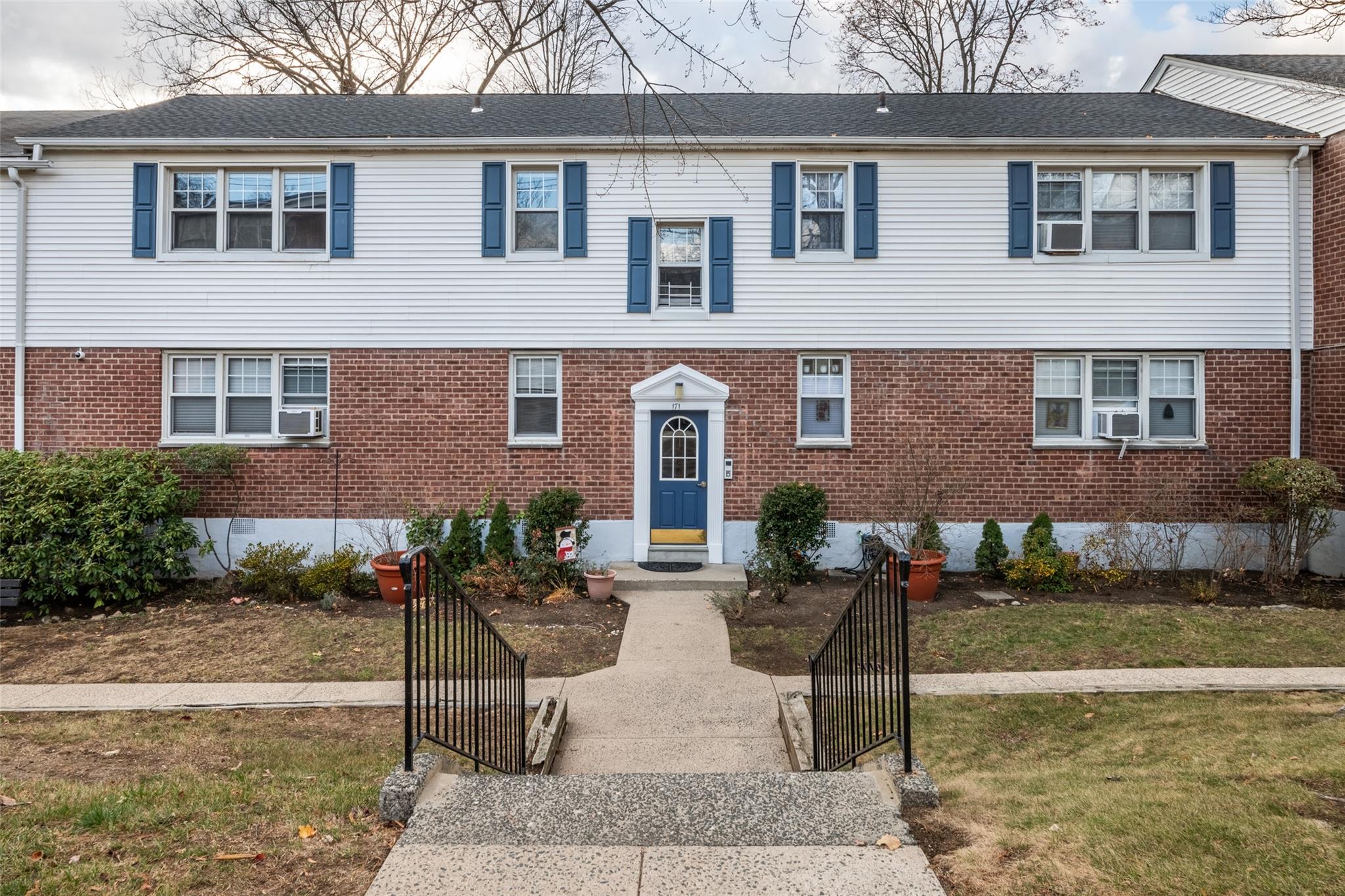 View of front of house with a front yard and cooling unit