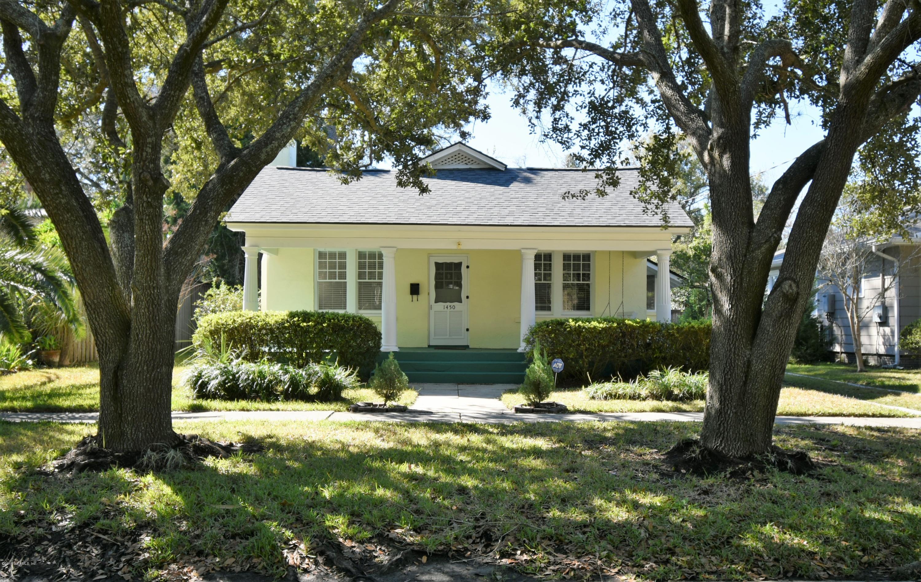 a front view of house with yard and trees around