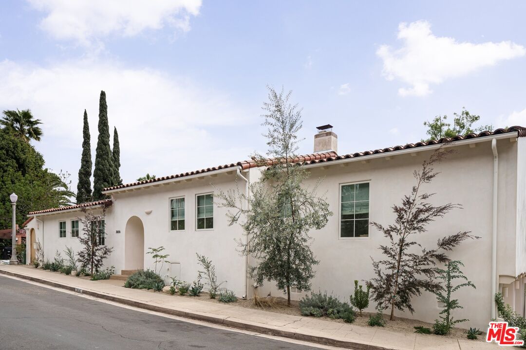 a front view of a house with a tree