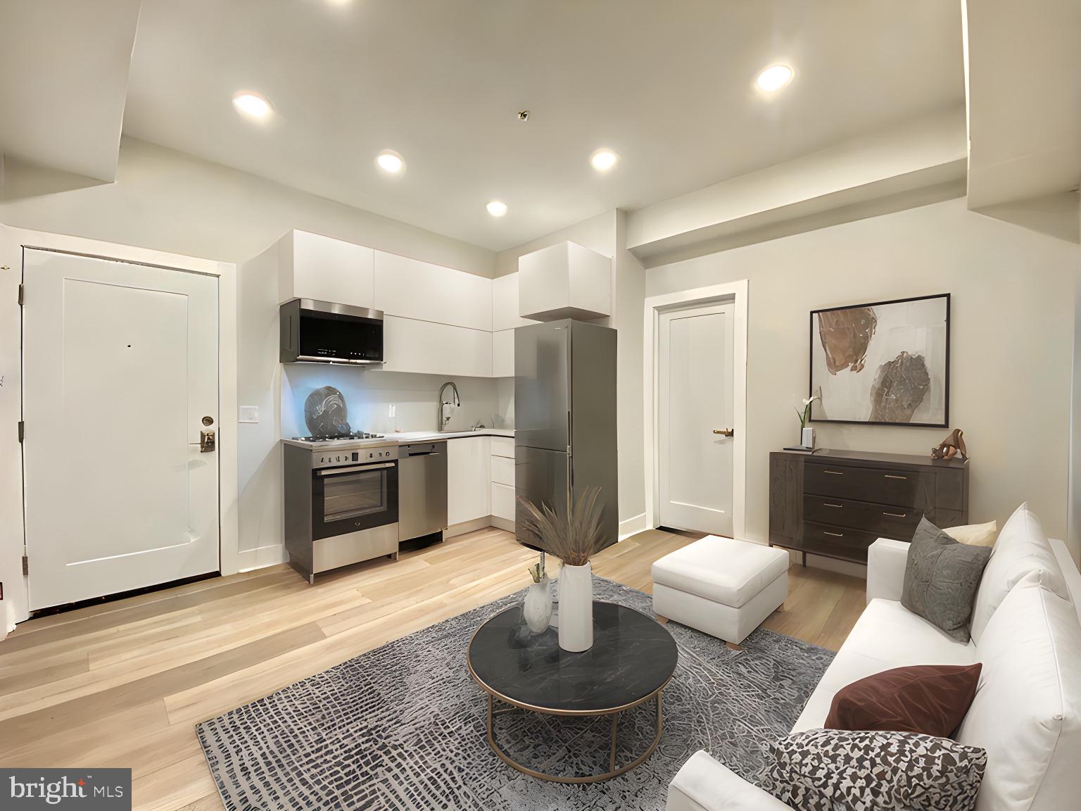 a living room with furniture and a view of kitchen