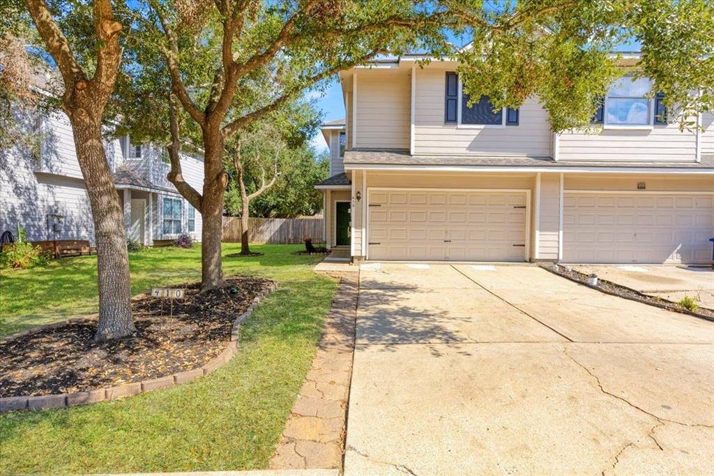 a view of a house with backyard and trees