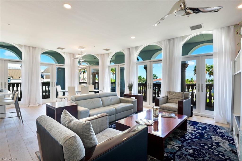 a living room with furniture kitchen view and large windows