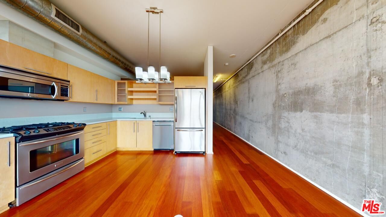 a kitchen with granite countertop wooden floors and stainless steel appliances