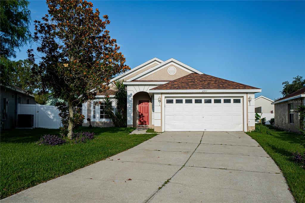 a front view of a house with a garden and trees