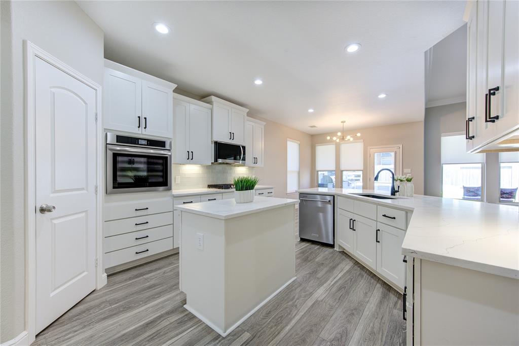 a kitchen with granite countertop white cabinets and stainless steel appliances