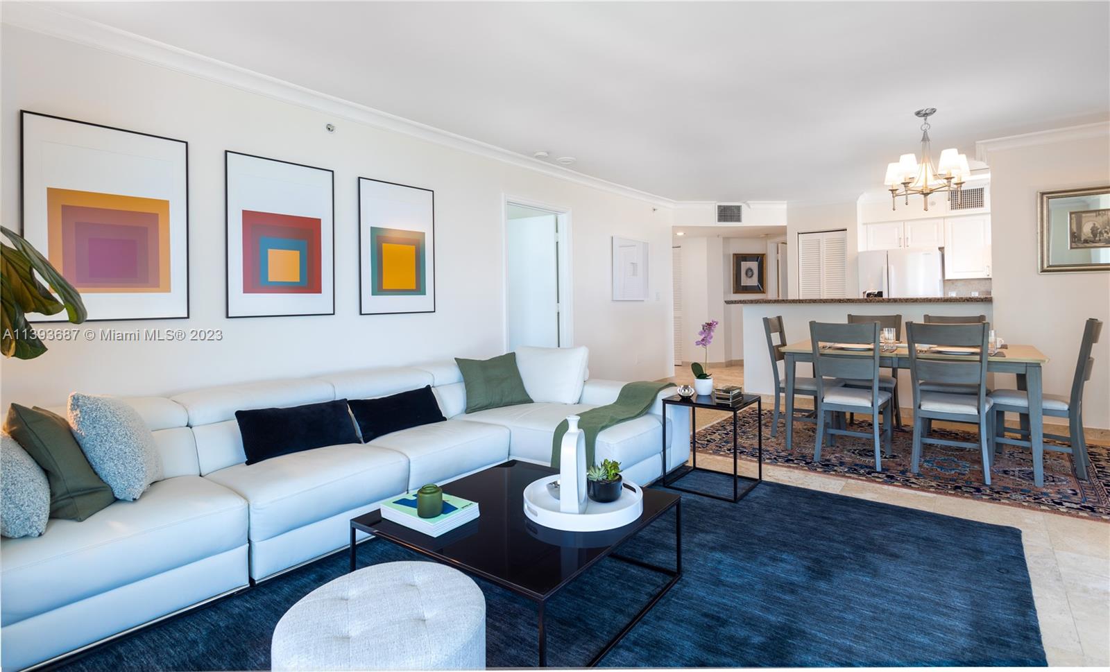 a living room with furniture dining table a lamp and a chandelier