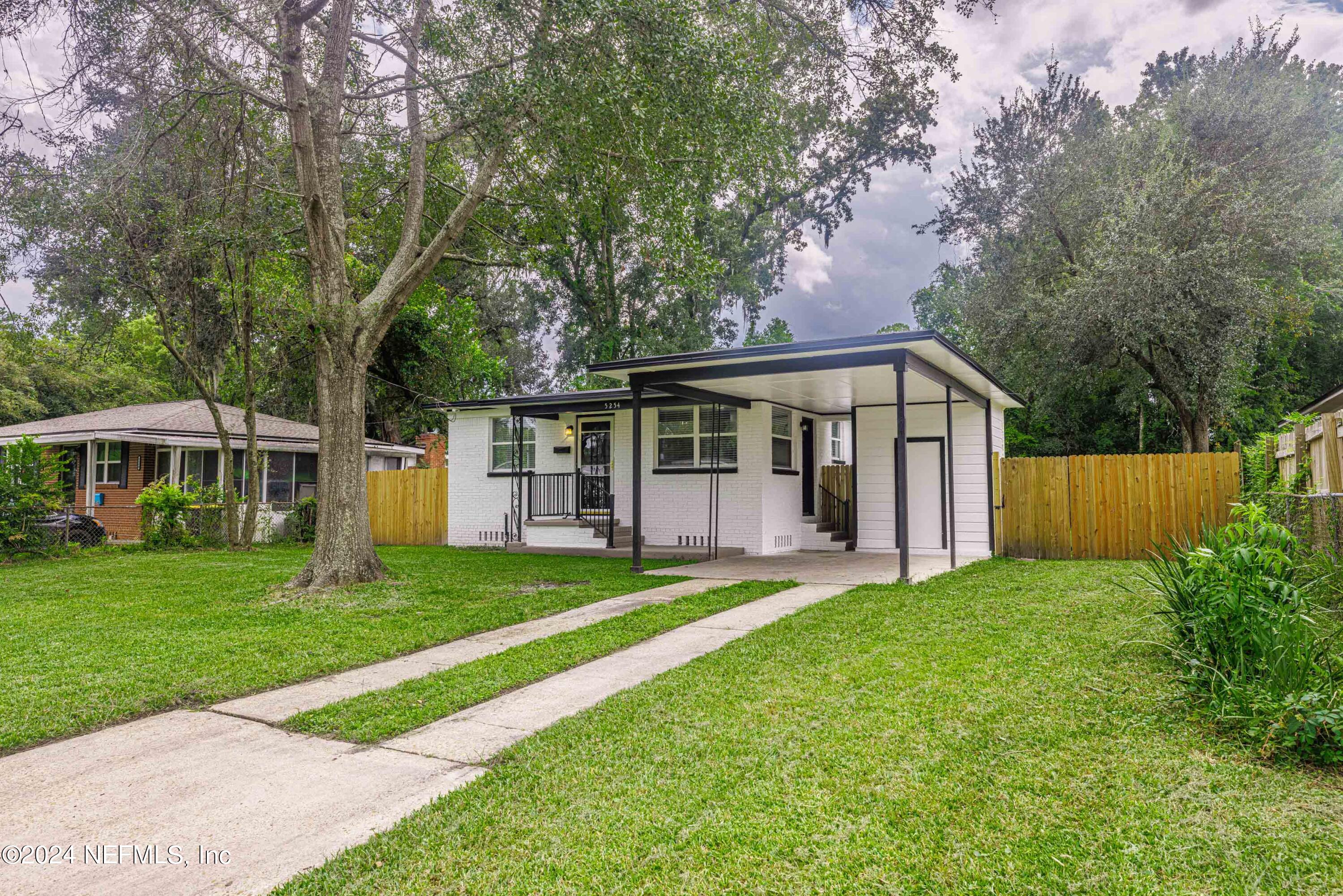 a front view of a house with a yard and trees