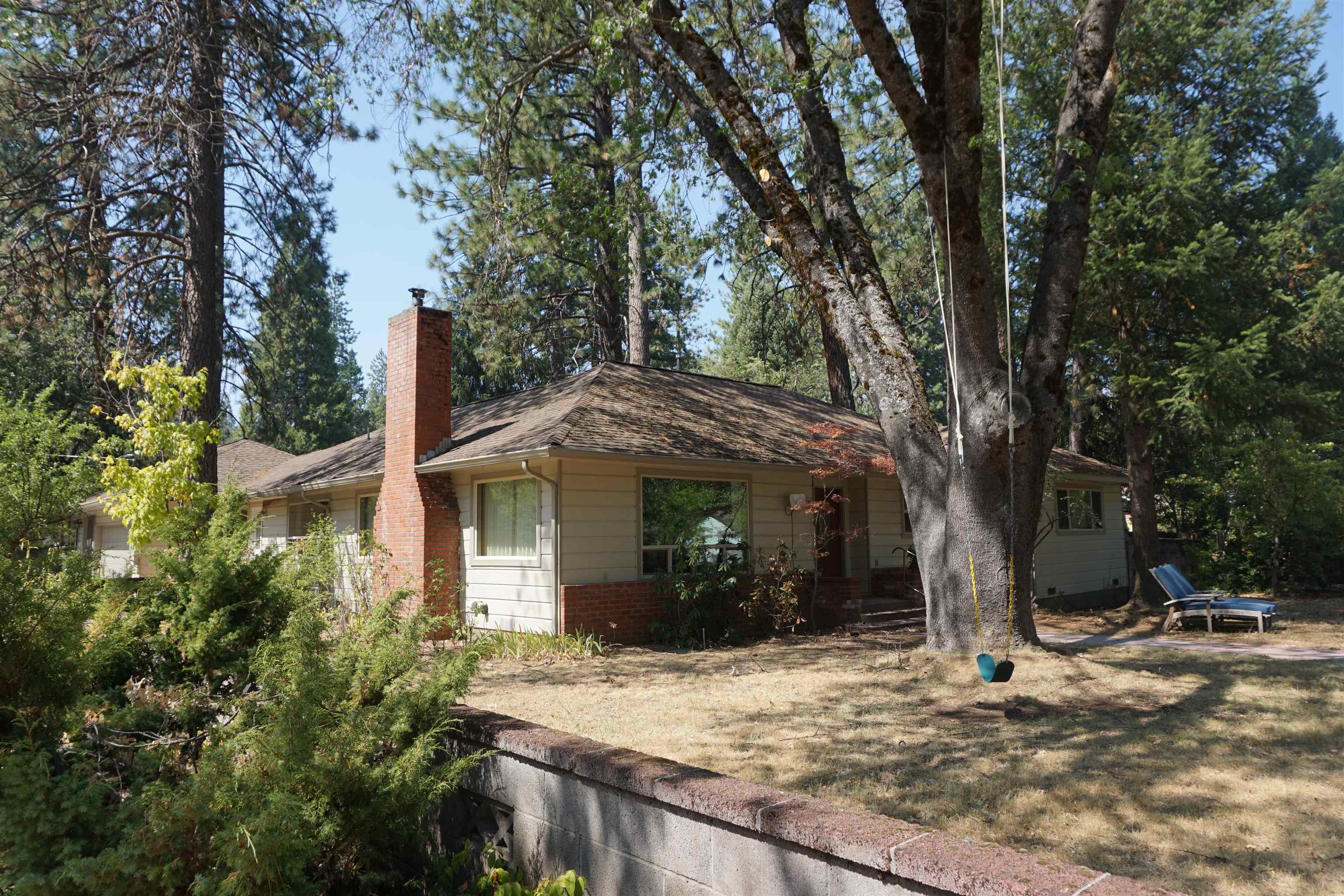 a view of a house with backyard and trees